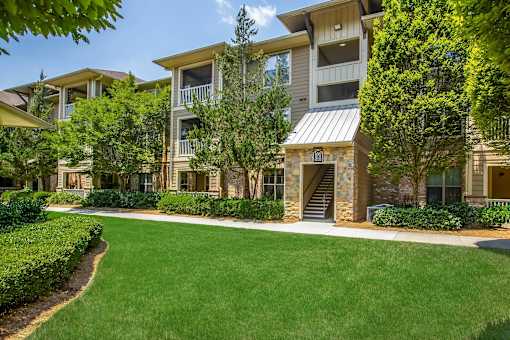 Apartment complex with a green lawn in front.