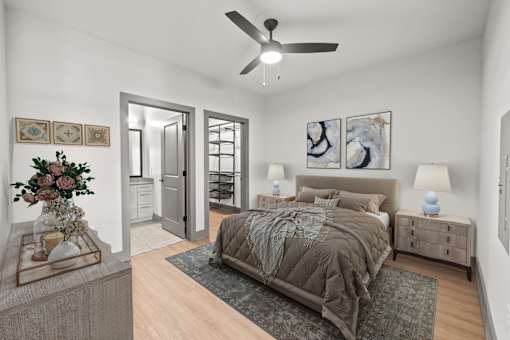A bedroom with a bed, nightstands, and a ceiling fan.
