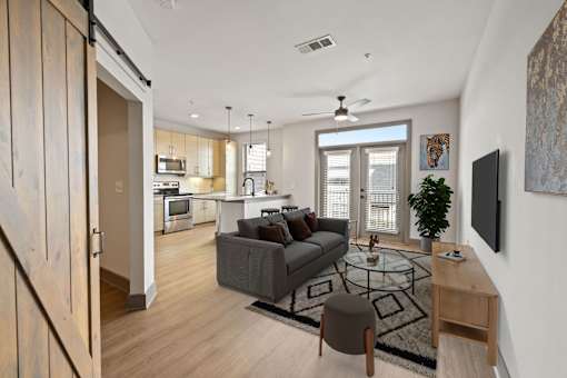 A modern living room with a grey couch and a glass coffee table.