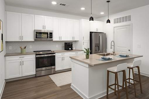 a large kitchen with white cabinets and stainless steel appliances