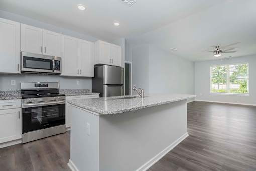A kitchen with white cabinets and a large island.