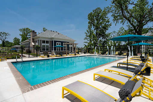 A pool with a yellow and black lounge chair.