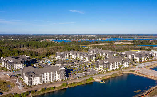 A large resort with a body of water in front of it.