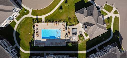 An aerial view of a building with a pool in front of it.