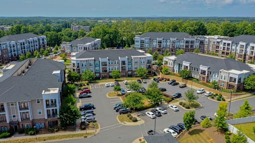 A bird's eye view of a parking lot surrounded by apartment buildings.