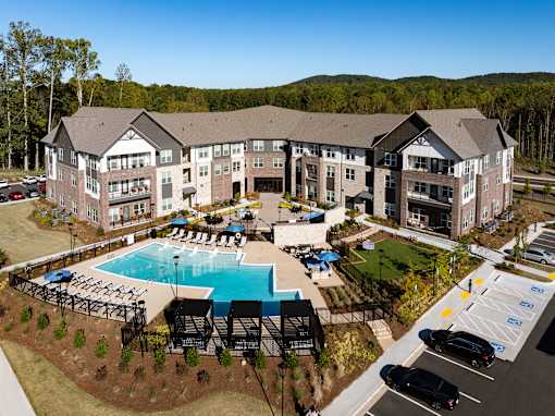 A large building with a pool in front of it.