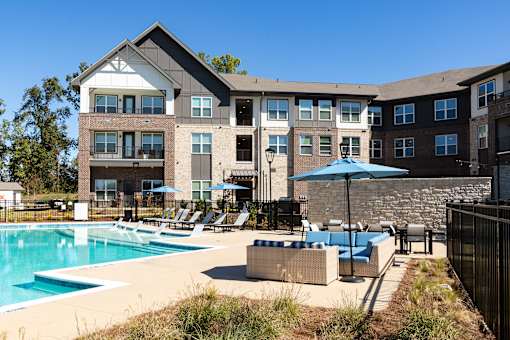 A large building with a pool in front of it.
