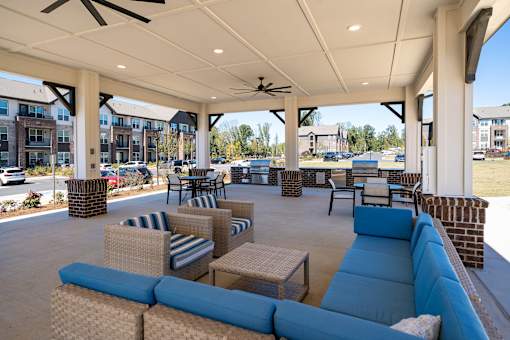 A patio with blue couches and a ceiling fan.
