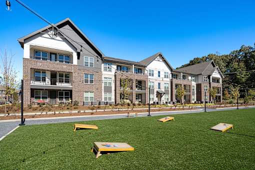 A row of modern houses with a green lawn in front.