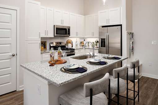 A kitchen with a granite countertop and white cabinets.