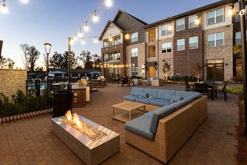 A patio with a fire pit and seating area.