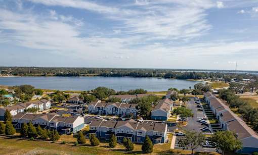 A large housing development with a body of water in the background.