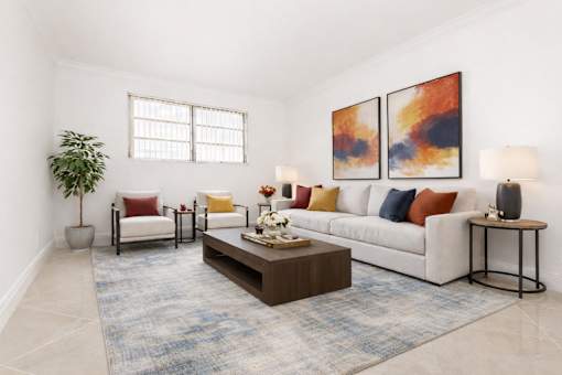 Pet-Friendly Luxury Apartments In Hollywood, FL - Park Hill Hollywood - A Bright, Modern Living Room With A White Sofa, Colorful Accent Pillows, And Large Abstract Wall Art.