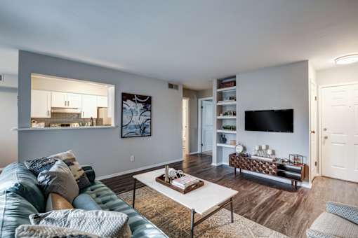 A living room with a blue couch and a white coffee table.