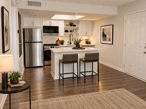 A kitchen with a refrigerator, stove, and bar stools.
