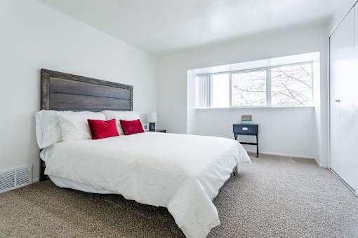 A bedroom with a large bed and a small nightstand.