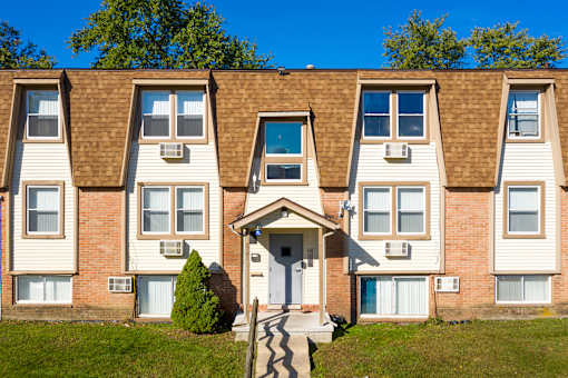 A row of townhouses with a clear blue sky above.