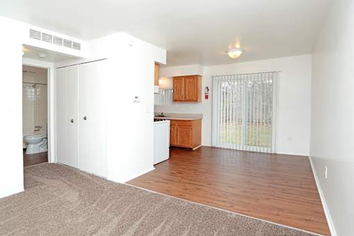 A white room with a brown rug and a wooden counter.