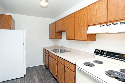 A kitchen with a white fridge and a white stove.