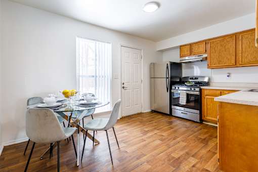 A kitchen with a table and chairs in front of a window.