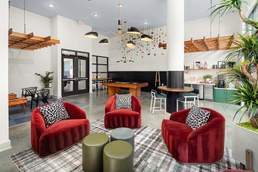 a living room with red chairs and a table
