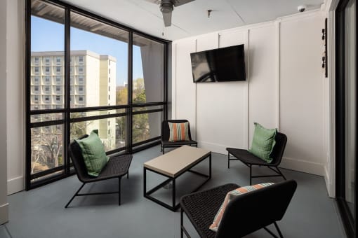 a living room with chairs and a table and a television