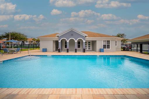 A swimming pool in front of a house.