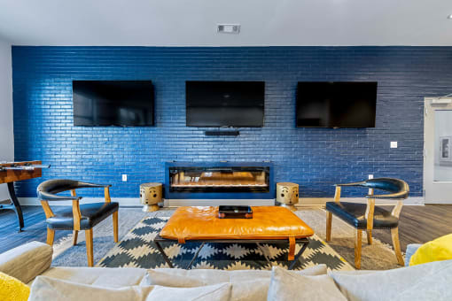 a living room with a blue brick wall and a fireplace