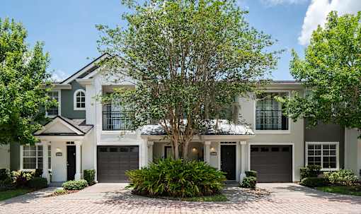 the exterior of a house with a tree in front of it