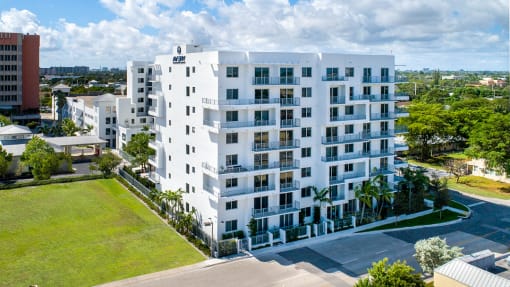 an aerial view of a white apartment building with grass and trees at Saba Pompano Beach, Pompano Beach, 33062