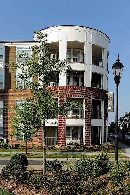 A modern building with a curved design and a lamp post in front.