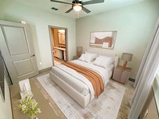 A bedroom with a bed, a ceiling fan, and a painting on the wall.