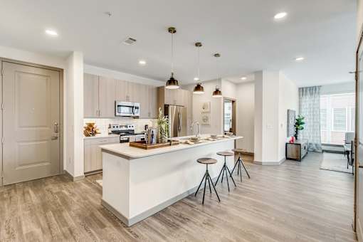A modern kitchen with a white island and bar stools.