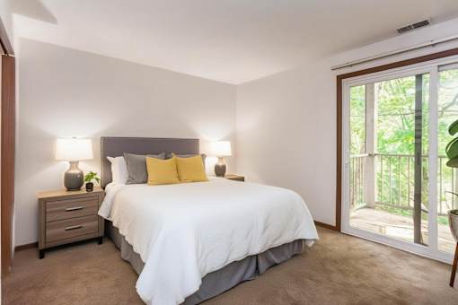 A bedroom with a bed, nightstand, and sliding glass doors at Winchell Way Apartment , Kalamazoo, 49008