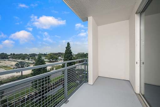 A balcony with a metal railing and a view of the outdoors.
