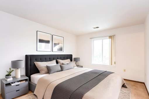 A bedroom with a large bed and a nightstand with a lamp at Winchell Way Apartment , Kalamazoo, 49008