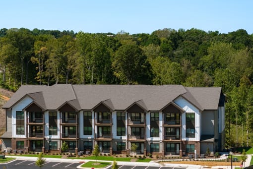 an aerial view of an apartment building with a forest in the background