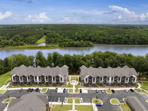 an aerial view of an apartment complex with a lake in the background