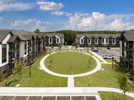 an aerial view of an oval lawn in front of apartment buildings