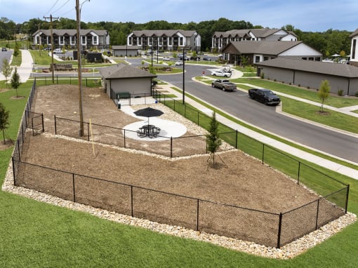 an aerial view of a fenced in park with a basketball court
