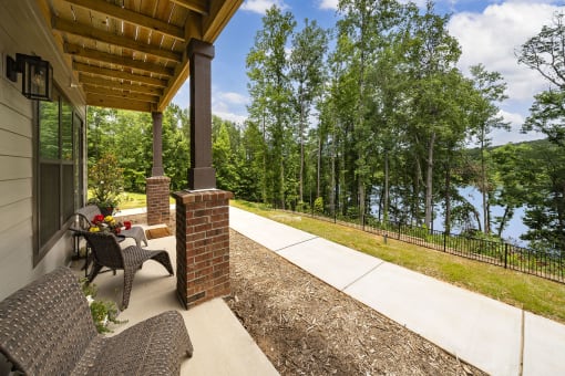 a covered porch with a view of a lake and trees