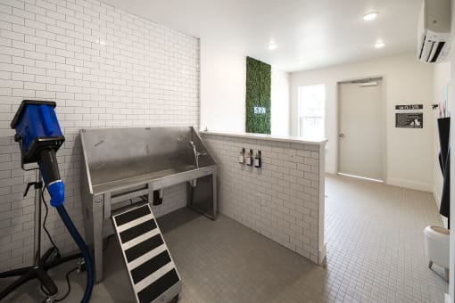 a large stainless steel sink in a room with a dryer