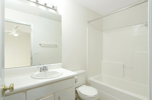bathroom with white cabinets and bath tub