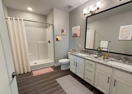 A bathroom with a toilet, sink, and shower.