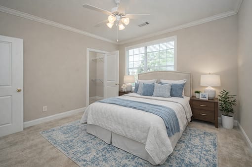 A bedroom with a large bed and a ceiling fan.