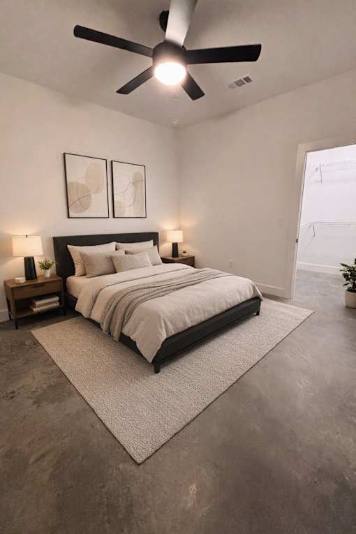 A bedroom with a large bed and a ceiling fan.