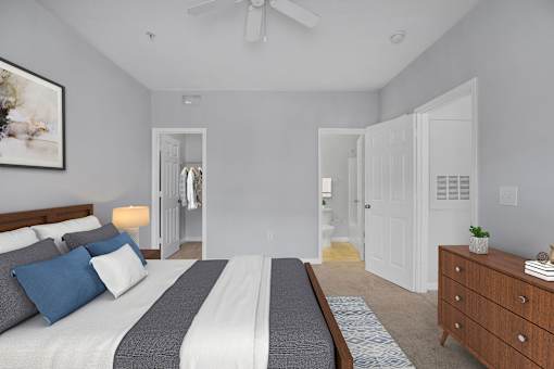 A bedroom with a bed, dresser, and mirror.