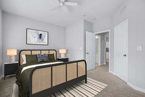 A bedroom with a bed, nightstands, and a painting on the wall.
