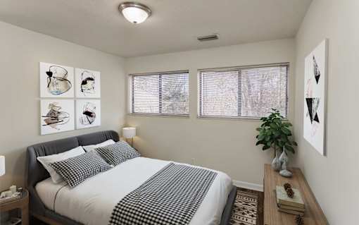 A bedroom with a bed, nightstand, and pictures on the wall.