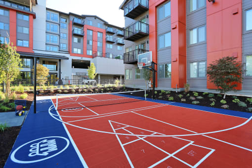 a basketball court in front of an apartment complex